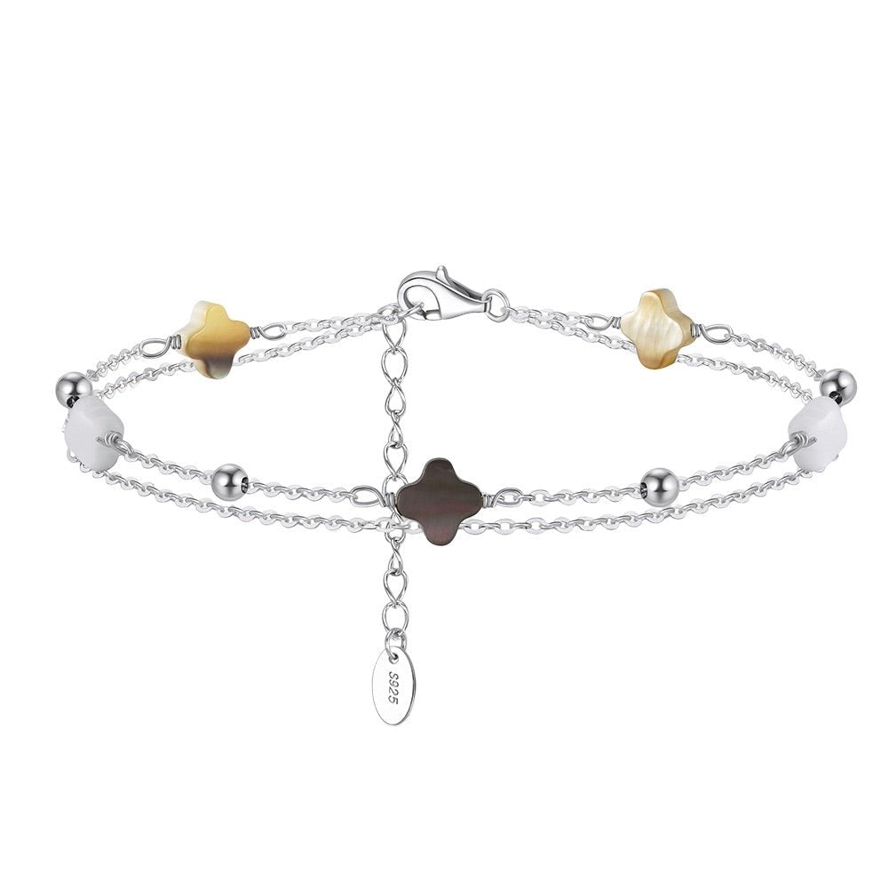 Bracelet double chaîne en argent 925 avec trèfles en nacre blanche et noire, design délicat et serti de petites perles.
