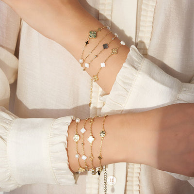 Bracelets double chaîne en argent 925 avec trèfles en nacre blanche et noire, style délicat et raffiné.