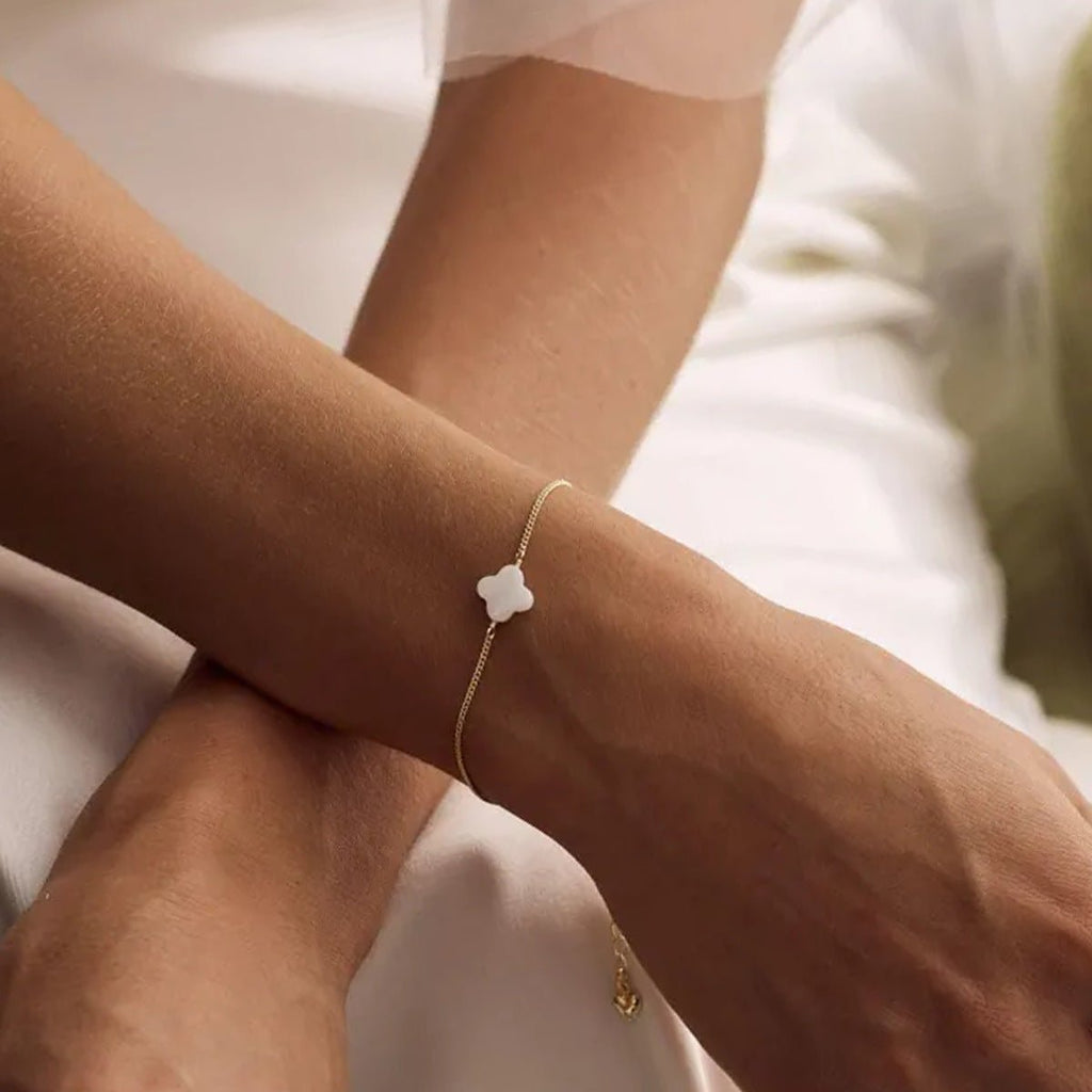 Bracelet fin doré avec pendentif trèfle en pierre naturelle blanche, chaîne réglable élégante.