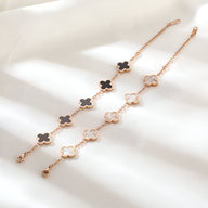 Bracelets magnétique en titane doré avec pendentifs trèfle, un noir et un blanc, pour femme.