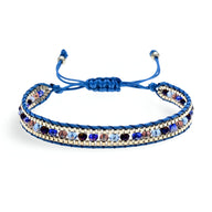 Bracelet tressé bleu avec perles de riz argentées et perles bleues foncées, fermeture ajustable nouée.