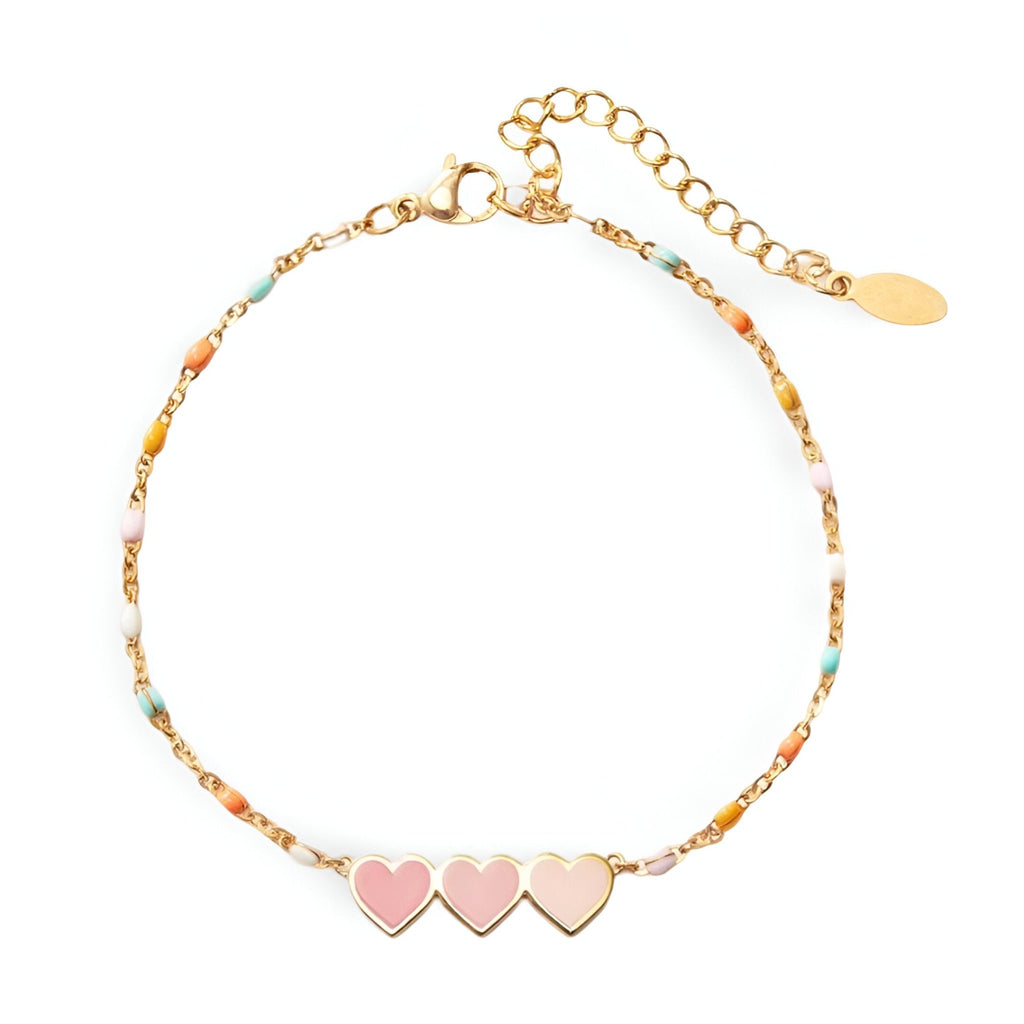 Bracelet femme or avec trois cœurs roses et chaîne fine à maillons et perles colorées.