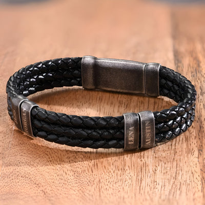 Bracelet triple cordon en cuir noir tressé avec double plaques en métal vieilli et fermoir magnétique.