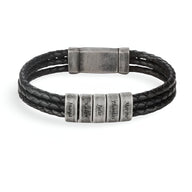 Bracelet homme noir triple cordon cuir avec cinq plaques métalliques gravées et fermoir magnétique.