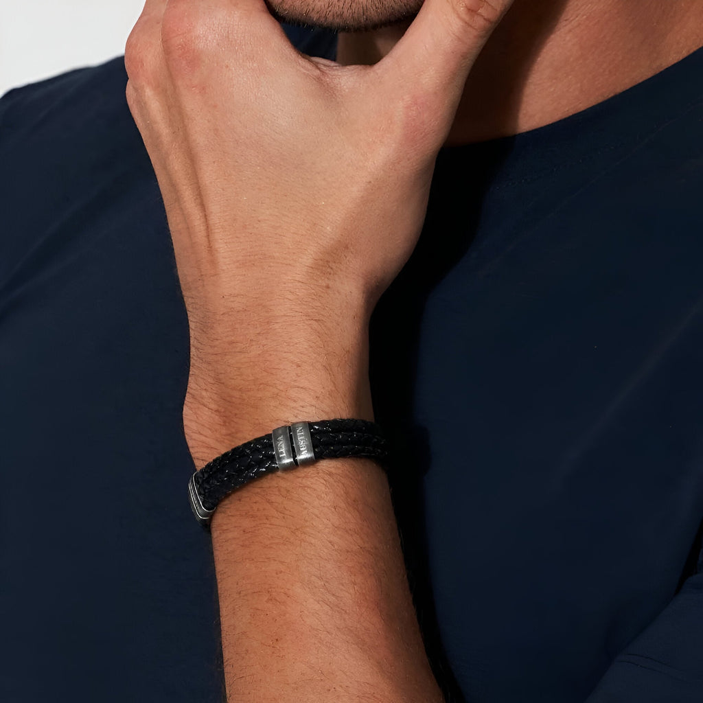 Bracelet homme triple cordon cuir noir avec trois plaques métalliques noires sur poignet.