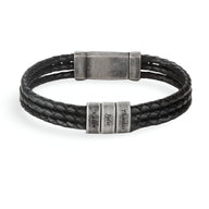 Bracelet homme noir triple cordon cuir tressé avec trois plaques métalliques gravées et fermoir aimanté gris vieilli.