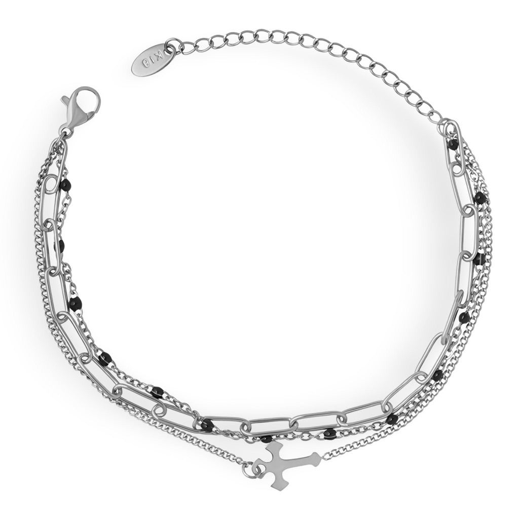 Bracelet triple mailles en titane plaqué or avec motif croix délicat et chaînette ajustable.