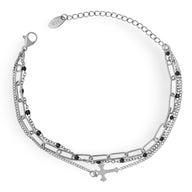 Bracelet triple mailles en titane plaqué or avec motif croix délicat et chaînette ajustable.