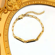 Bracelet femme en acier inoxydable or avec trois plaques gravées EMILY, ELEANOR, CHELSEA, chaîne fine et fermoir mousqueton.