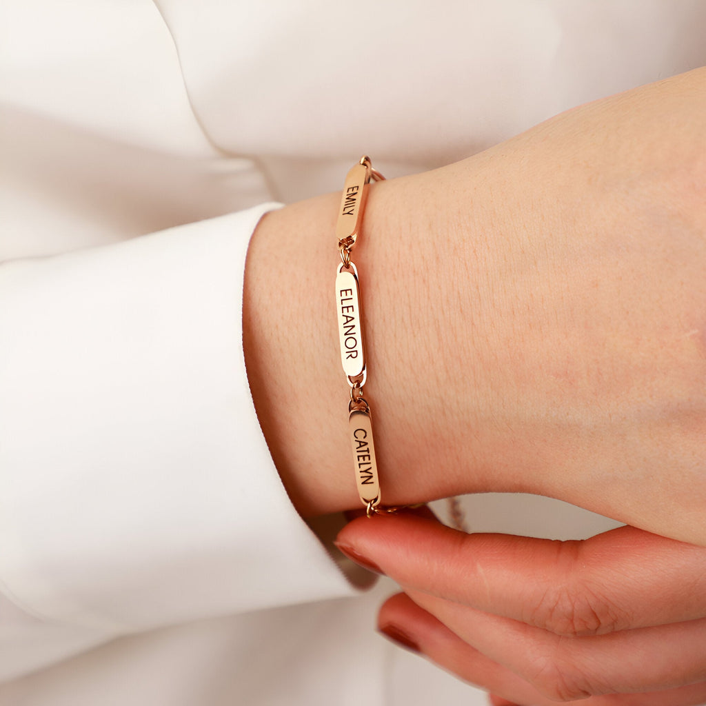 Bracelet or rosé avec trois plaques personnalisées en acier inoxydable porté au poignet féminin.