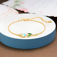 Bracelet en cuivre doré fin avec pendentif tulipe bleu et vert pour femme.