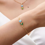 Bracelet fin en cuivre doré avec pendentif tulipe bleue et verte, style délicat et féminin.