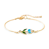 Bracelet en cuivre doré fin avec pendentif tulipe bleu et blanc émaillée et feuille verte.