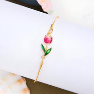 Bracelet fin en cuivre orné d'une tulipe rose avec feuilles vertes et détails dorés.
