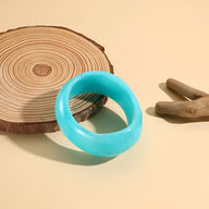 Bracelet épais en acrylique turquoise avec finition lisse et brillante.
