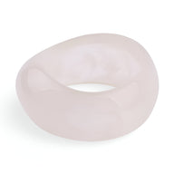 Bracelet épais en acrylique rose pâle, finition lisse et brillante, forme ronde généreuse.