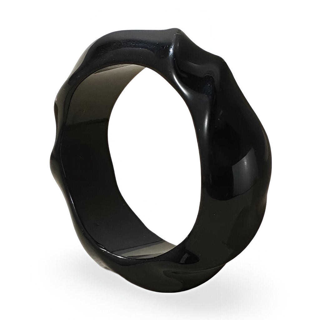 Bracelet rigide en acrylique noir avec surface ondulée et finition brillante.
