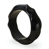 Bracelet rigide en acrylique noir avec surface ondulée et finition brillante.