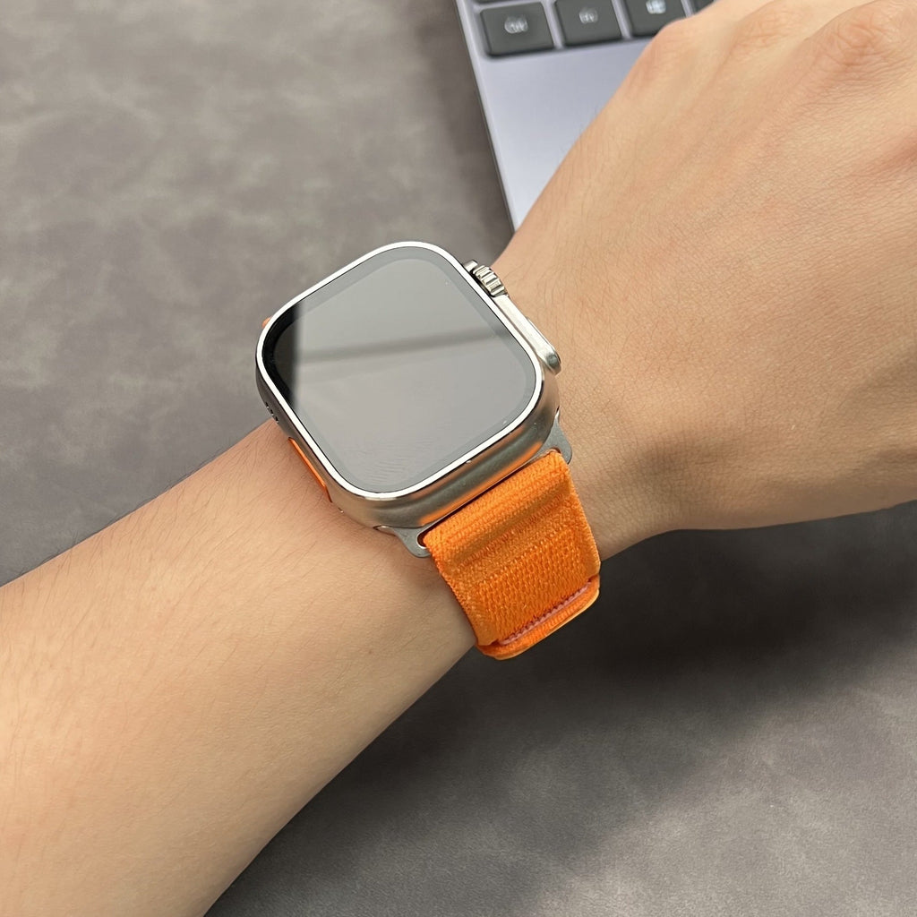 Bracelet velcro en nylon orange ultra léger et ajustable pour Apple Watch, modèle Mercury, porté au poignet.