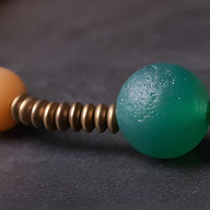 Bracelet vert en graines de Bodhi et perles agate orange avec anneaux métalliques dorés.