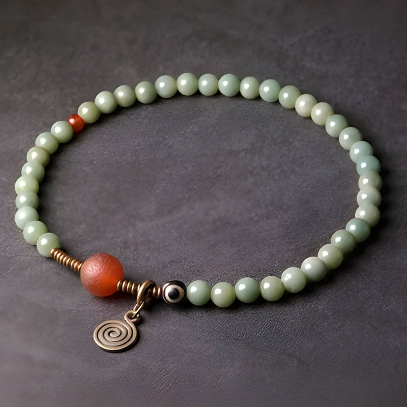 Bracelet femme perles vert clair en graines de Bodhi, pierre d'agate orange, pendentif spirale cuivre.