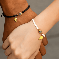 Bracelets couple cordons tressés noir et blanc avec cœur magnétique plaqué or et médaillon photo central.