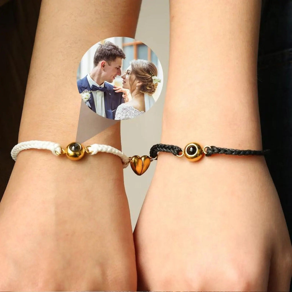 Bracelets couple en cordons tressés noir et blanc avec cœur magnétique plaqué or au centre.