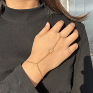 Bijou de main doré en acier inoxydable avec chaîne fine et cœur central délicat, modèle Dona.