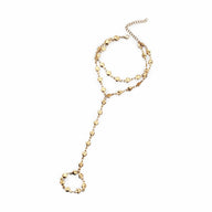 Bijou de main en acier inoxydable doré orné de petits cœurs et chaîne fine élégante.