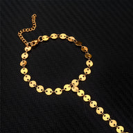 Bijou de main en acier inoxydable doré, médaillons ronds et chaîne fine pour femme.