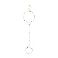 Bijou de main doré en acier inoxydable avec perles et chaîne délicate reliant un bracelet et une bague.