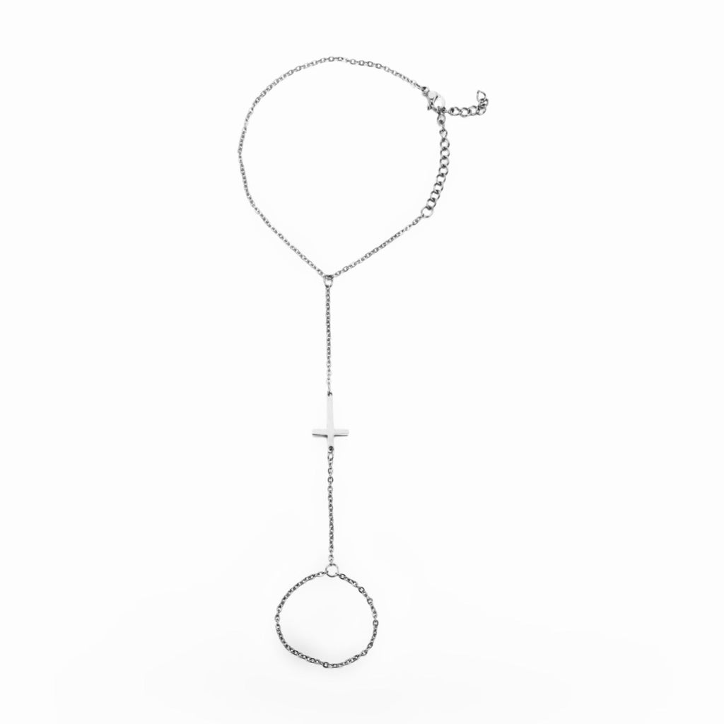 Bracelet de main en acier inoxydable argenté avec chaîne fine et croix centrale minimaliste.