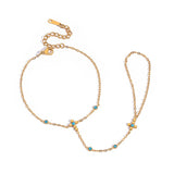 Chaîne de doigt en acier inoxydable doré avec perles turquoise et petite croix chrétienne centrale.