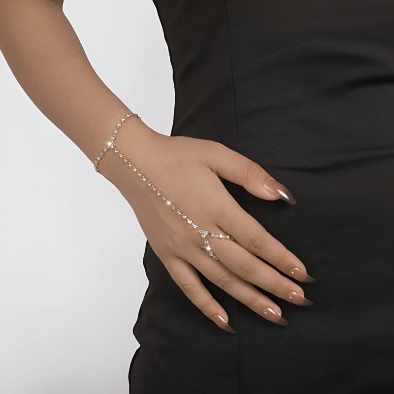 Bijou de main argenté en acier inoxydable orné de zirconiums brillants, porté sur la main féminine.