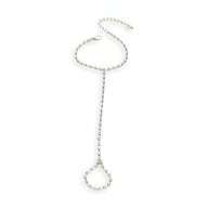 Bijou de main en acier inoxydable argenté avec chaîne fine et anneau décoré de zirconiums en forme de cœur.