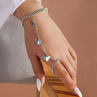 Bracelet chaîne argenté avec motifs papillons reliant le poignet au doigt en acier inoxydable.
