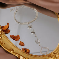 Bijou de main en acier inoxydable argenté avec chaîne et motifs papillons délicats.