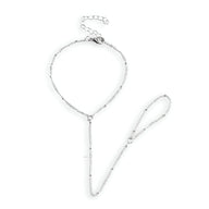 Bijou de main en acier inoxydable argenté avec bracelet chaîne et anneau reliés par une fine chaîne.