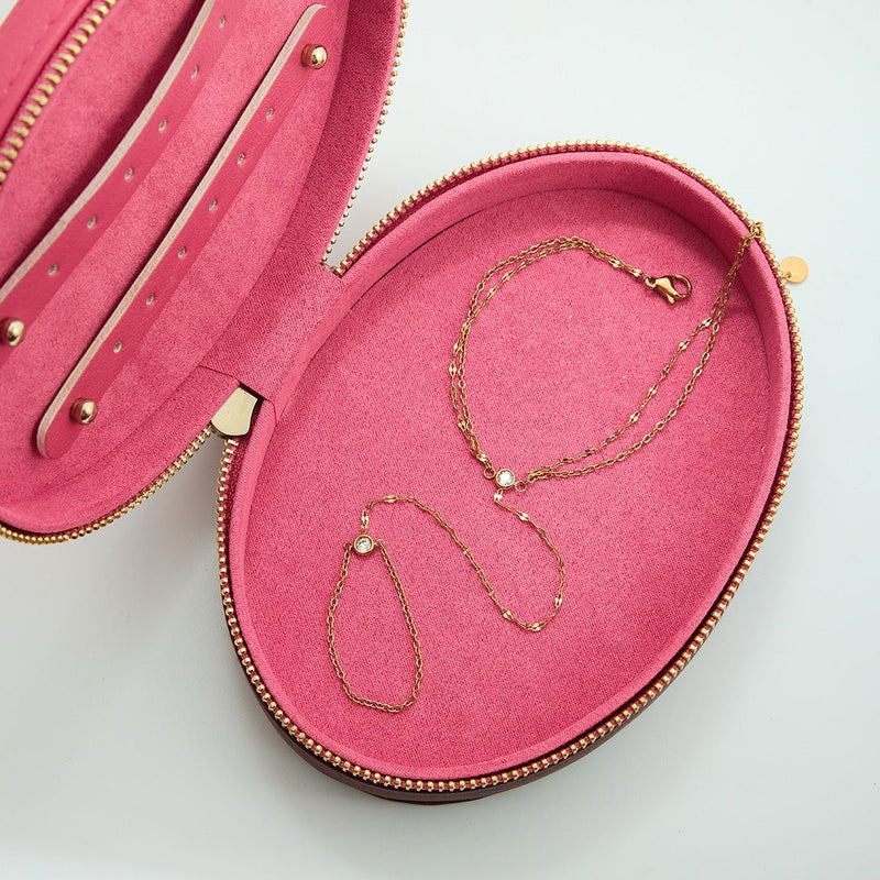 Chaîne de doigt et bracelet en acier inoxydable doré avec maille fine brillante, présentés dans un écrin rose élégant.