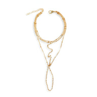 Bijou de main multi-rangs en acier inoxydable doré avec chaînes fines et anneau connecté pour doigt.