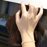 Bijou de main en perles blanches avec chaîne fine en acier inoxydable argenté, modèle Omnia.