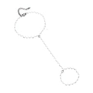 Bijou de main argenté en acier inoxydable avec chaîne fine et perles délicates, modèle Omnia.