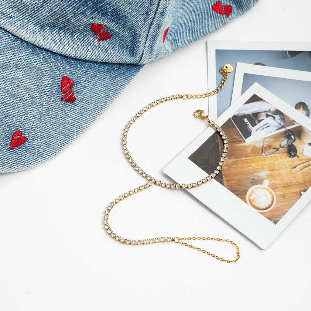 Chaîne de main dorée à l’or fin avec petits zircons scintillants et fines mailles délicates.