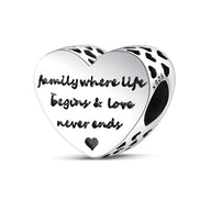 Charm cœur en argent avec inscription "family where life begins & love never ends" et petits cœurs noirs.