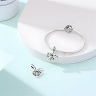 Bracelet argent avec charm arbre de vie orné de pierres bleues et blanches.