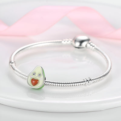 Bracelet argenté avec charm avocat vert clair et noyau en forme de cœur rougeî.