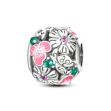 Breloque argent floral avec fleurs roses émaillées, cristaux verts et roses, motif délicat.