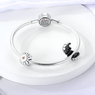 Bracelet argent avec charm marguerite blanche et détail cœur doré, fermoir rond gravé.