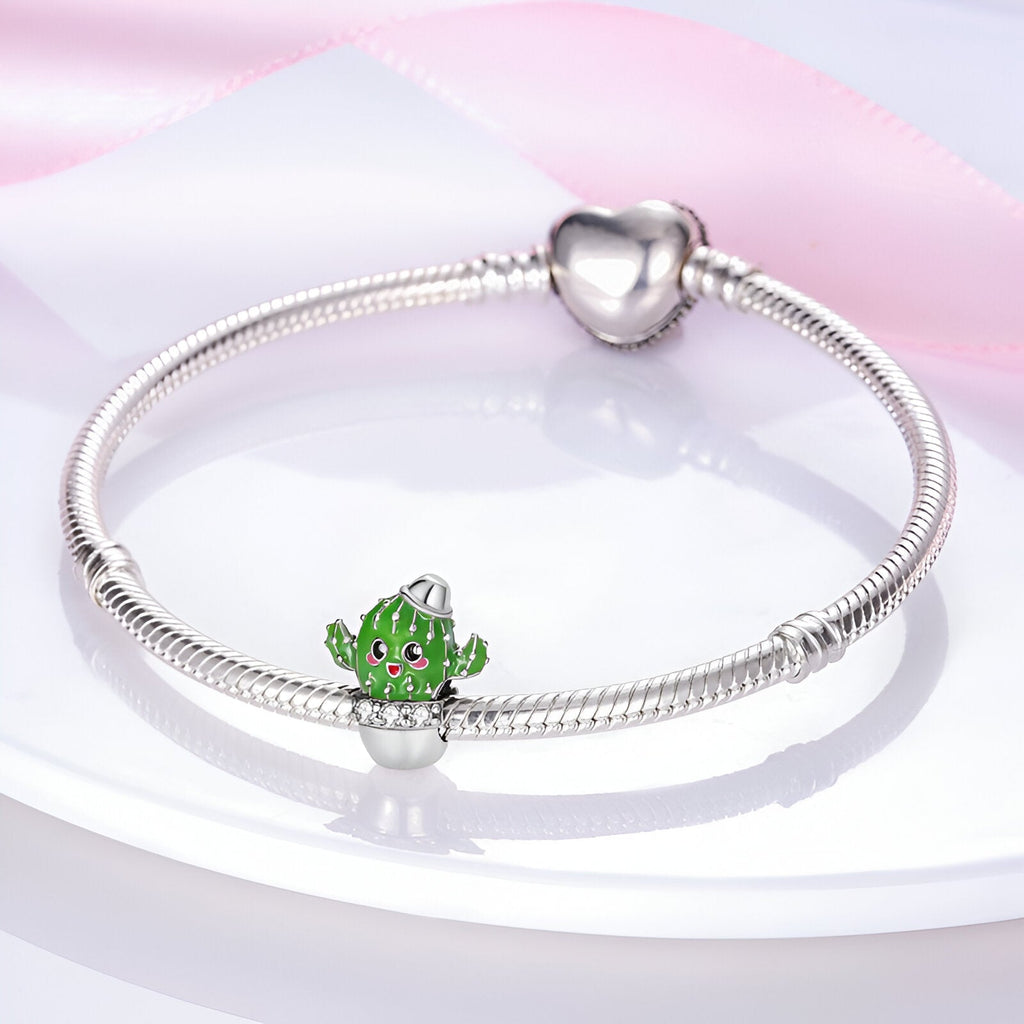 Bracelet argenté avec charm cactus vert souriant et fermoir en forme de cœur.