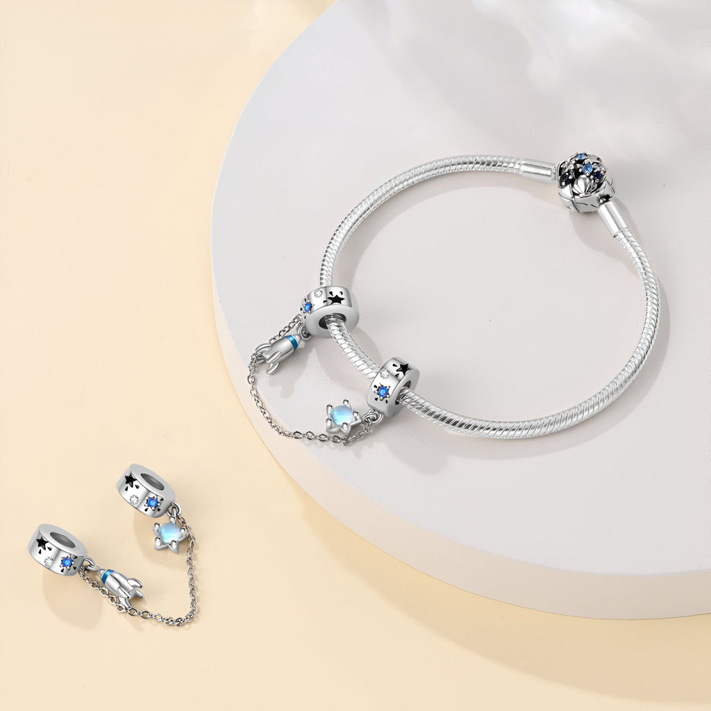 Bracelet argenté avec charm fusée spatiale et étoile en chaîne délicate.